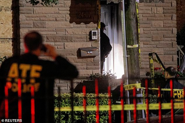 Law enforcement officials investigate outside the house on Tuesday night