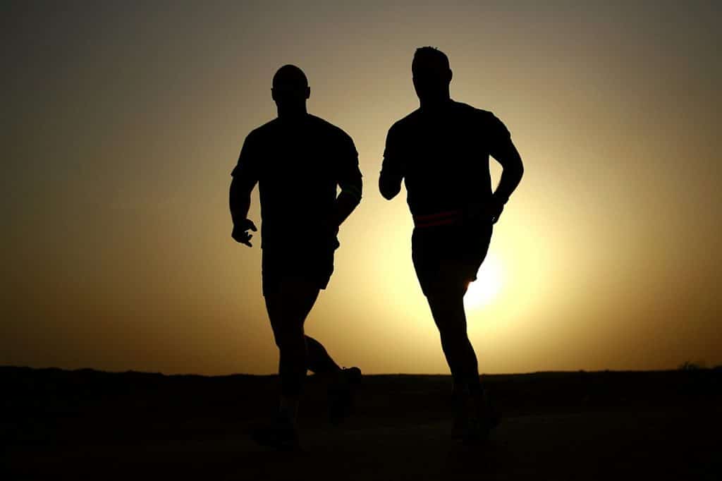 Two shadowed men running in the early morning with the sun rising behind them. Does running increase testosterone?