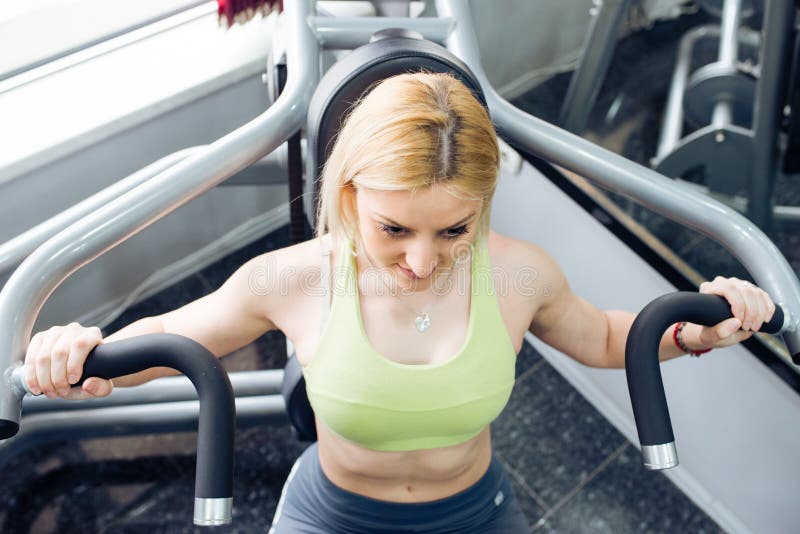 Arms exercise in gym. Blonde girl royalty free stock image
