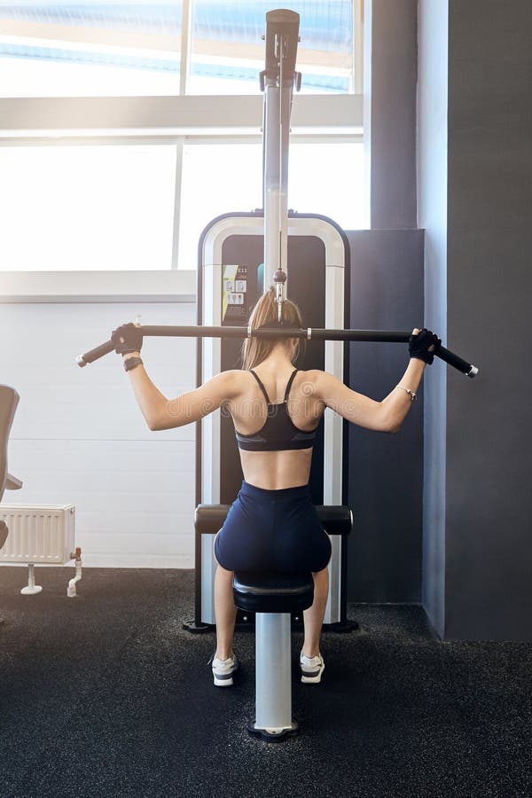 Beautiful sport girl is engaged on a simulator in the gym. stock image