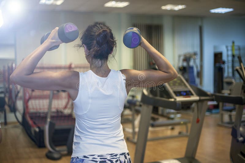 Fitness exercises, a woman performs an exercise bar  press on the shoulders. Fitness exercises, a woman performs an exercise bar press on the shoulders stock photo