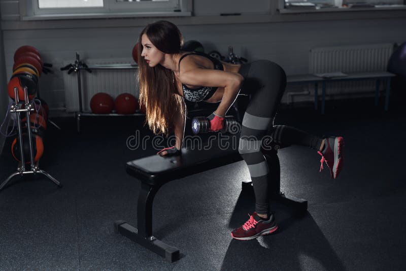 Fitness girl execute exercise with dumbbells, on broadest muscle of back. Fitness girl execute exercise with dumbbells, on broadest muscle of back stock photography