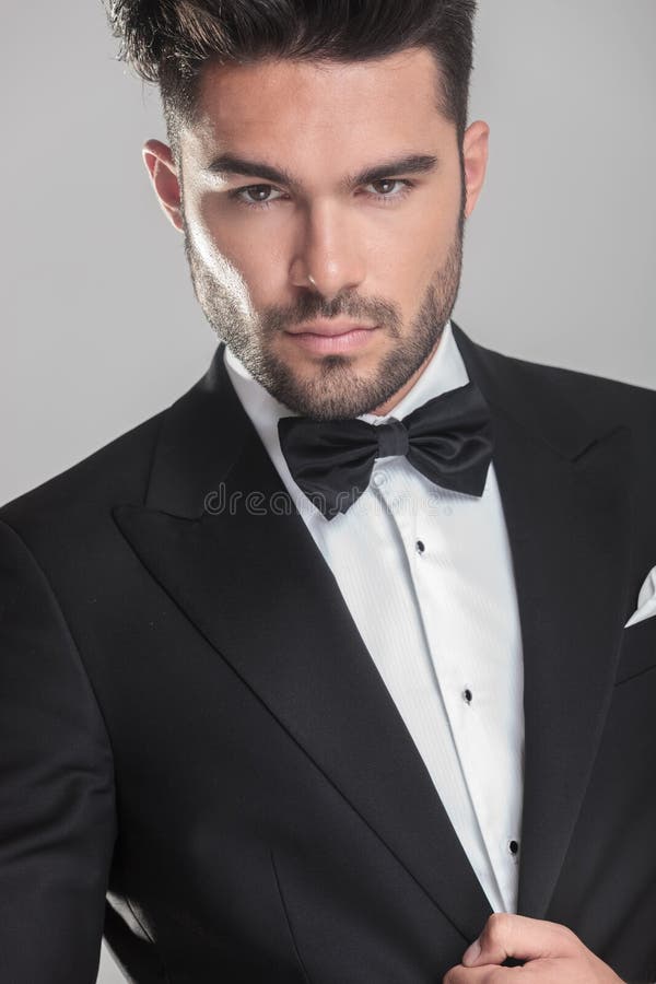 Handsome young man in tuxedo ajusting his jacket stock photo