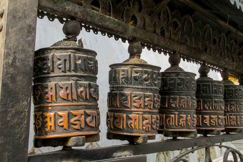 Prayer wheel in Nepali near the Buddhist temple. Round rotating prayer wheel Nepali drum in the Buddhist temple in the Himalayas, Nepal. A colorful Nepali drum royalty free stock photo