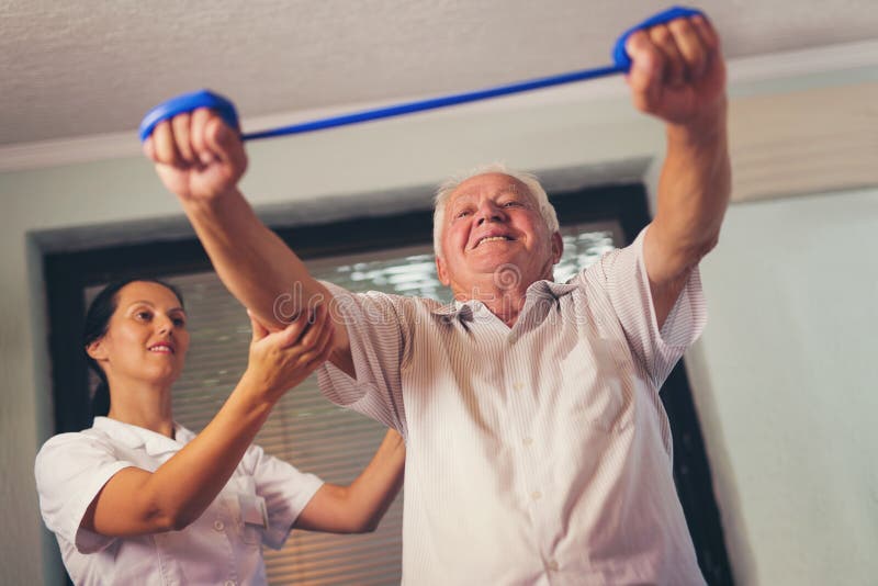 Senior man doing exercises using a strap. Senior men doing exercises using a strap to extend and strenthen her neck and shoulder muscles stock photography