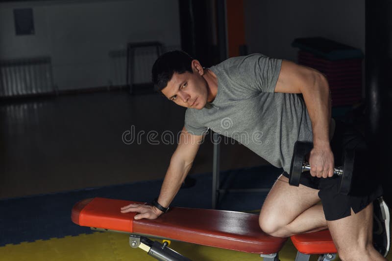 Very power athletic guy , execute exercise with dumbbells, on broadest muscle of back. Very power athletic guy , execute exercise with dumbbells, on broadest stock photo
