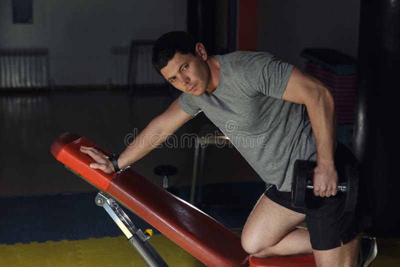 Young handsome adult man execute exercise with dumbbells, on broadest muscle of back. Young handsome adult man execute exercise with dumbbells, on broadest royalty free stock photos