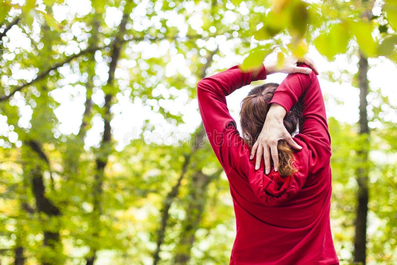 Young woman stretching arm and shoulder outdoors. Fitness woman doing warm up exercises stock image