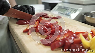 Chef cuts red pepper on cutting board in industrial kitchen. Hot-tasting powder prepared from dried and ground peppercorns, commonly used as spice condiment stock video footage