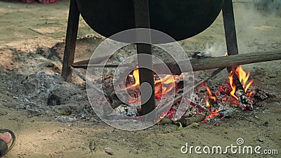 Someone adjusts burnt log with raker under black pot. Hiking stuff to do. Someone adjusts burnt log with raker under black pot stock footage