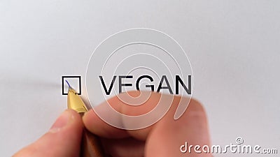 VEGAN - Man hand draw a tick in the checkbox on white paper with pen. Marking checkbox with the inscription - VEGAN. Diet, vegetarian lifestyle, eco products stock footage