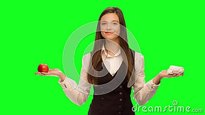 Woman choosing to eat burger instead of apple Selects apple. Woman choosing to eat burger instead of apple Green screen keying in a single click, correct skin stock video footage