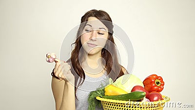 Young woman holding a basket, gets out of the basket head of garlic and assesses its.  stock footage