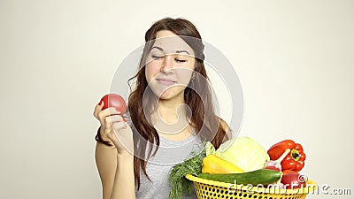 Young woman holding a basket, gets out of the basket of tomatoes and assesses its.  stock video footage