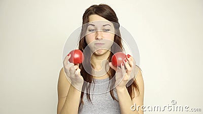 Young woman holding two tomatoes and expresses different emotions. healthy food - strong teeth concept.  stock video footage